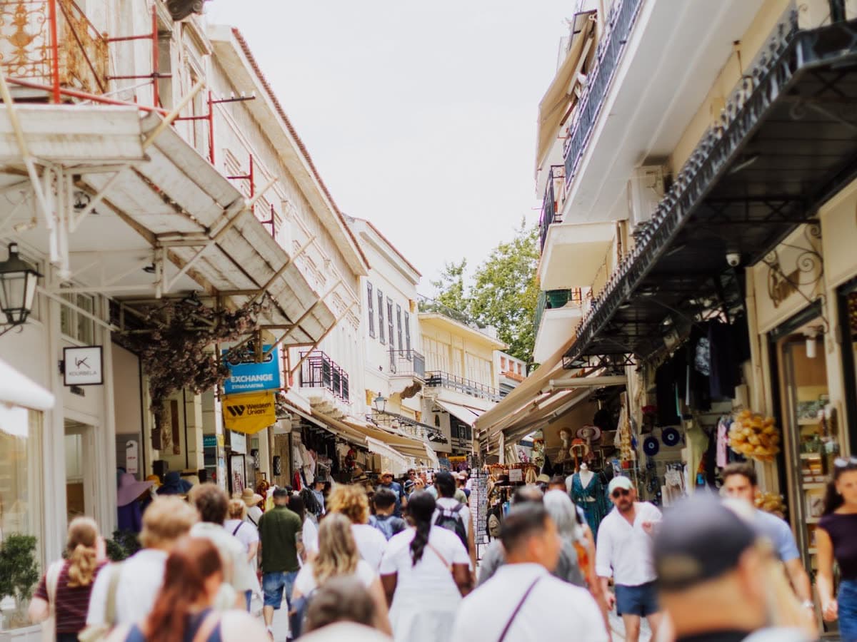 Visitors walking a marble street in Plaka, below the Acropolis